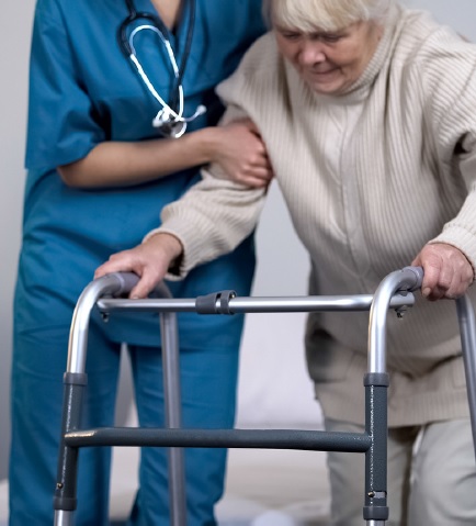 Nurse Helping Elderly woman to walk after Hip Replacement Surgery